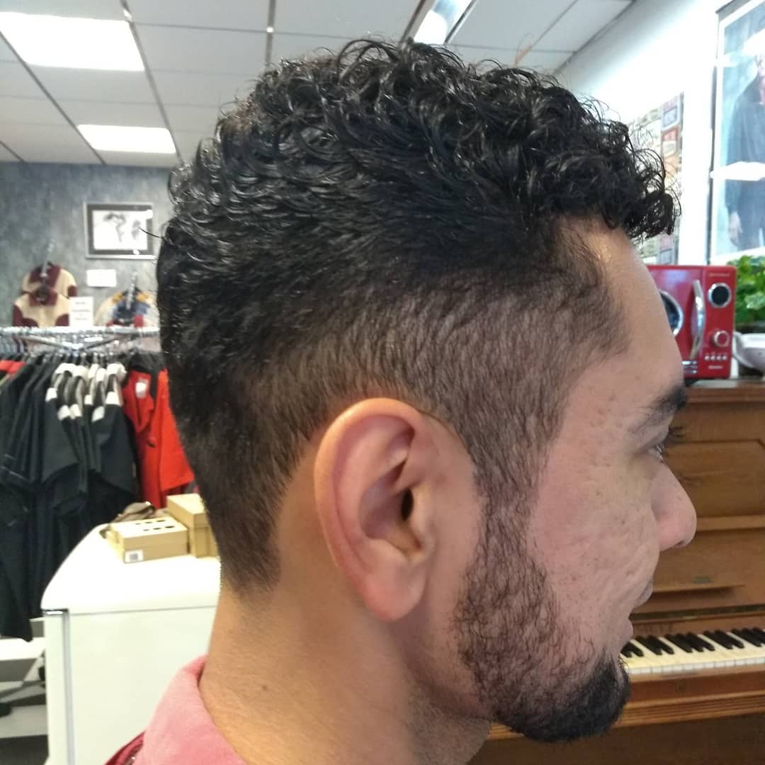 Krullen bovenop met een skin fade en baard